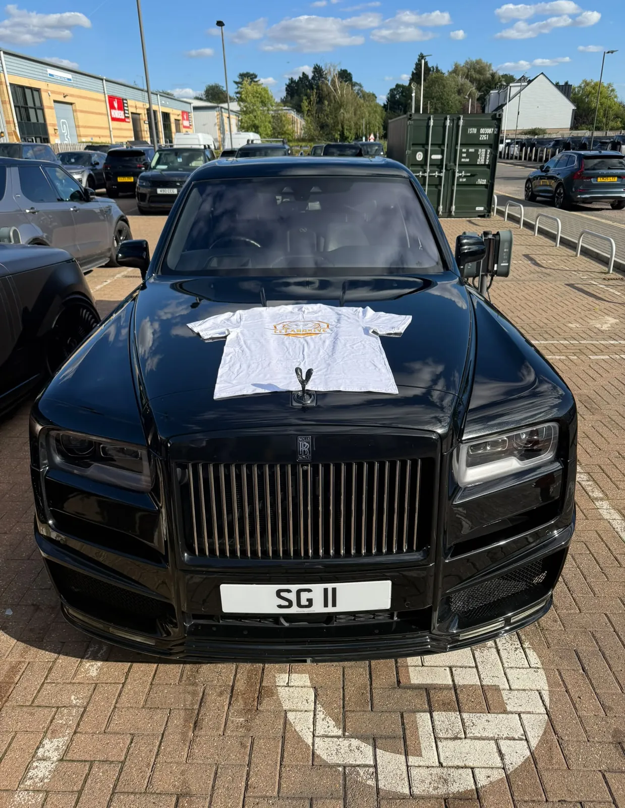 Black Rolls-Royce Cullinan with a Cleardrive t-shirt on its bonnet